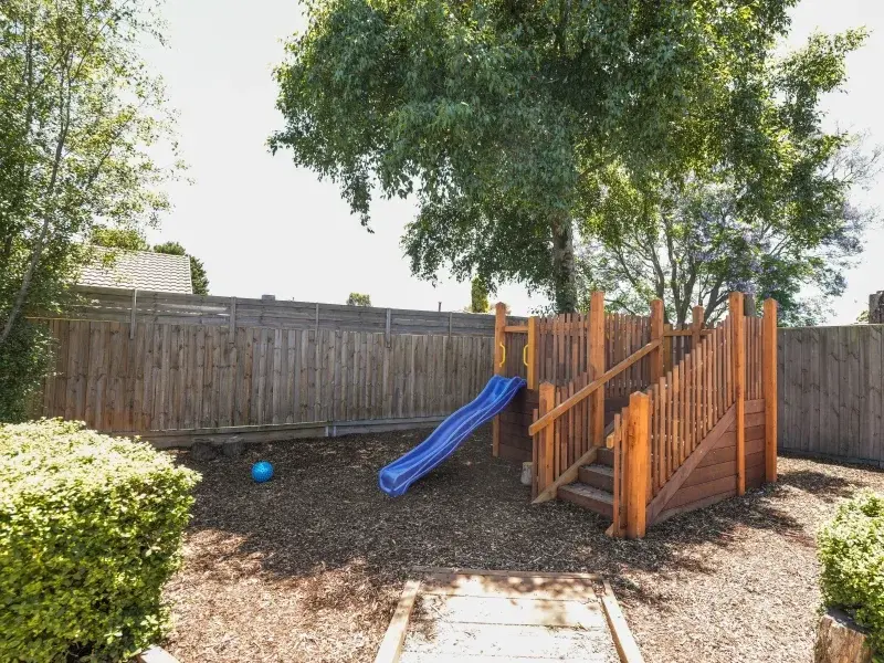 Children playing on sustainable wooden playground equipment at Little Stars Group Time: Children sitting in a circle for story time with a qualified early childhood teacher